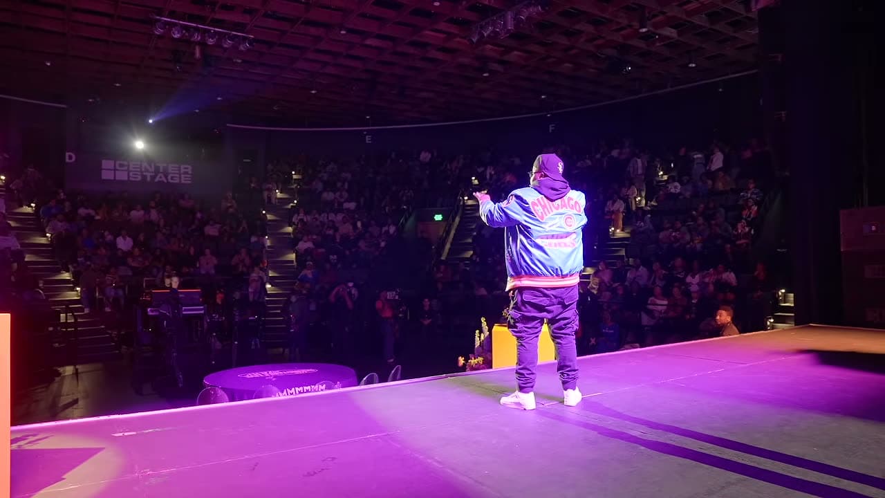 The host hyping a full house under the stage lights