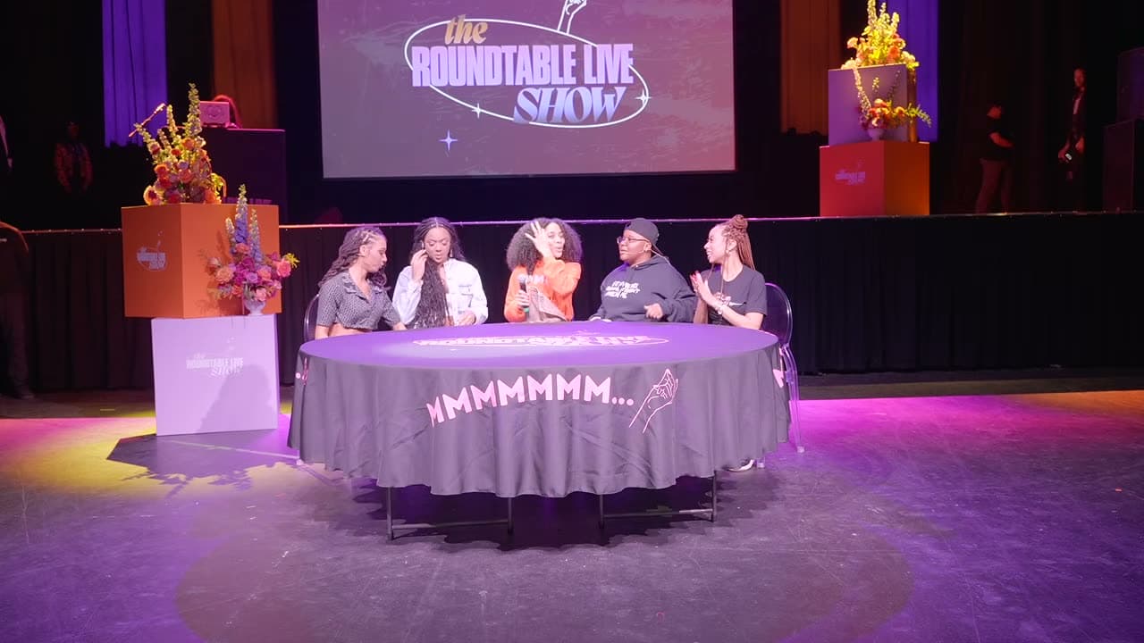 The branded round table, florals and screens that made up the stage design