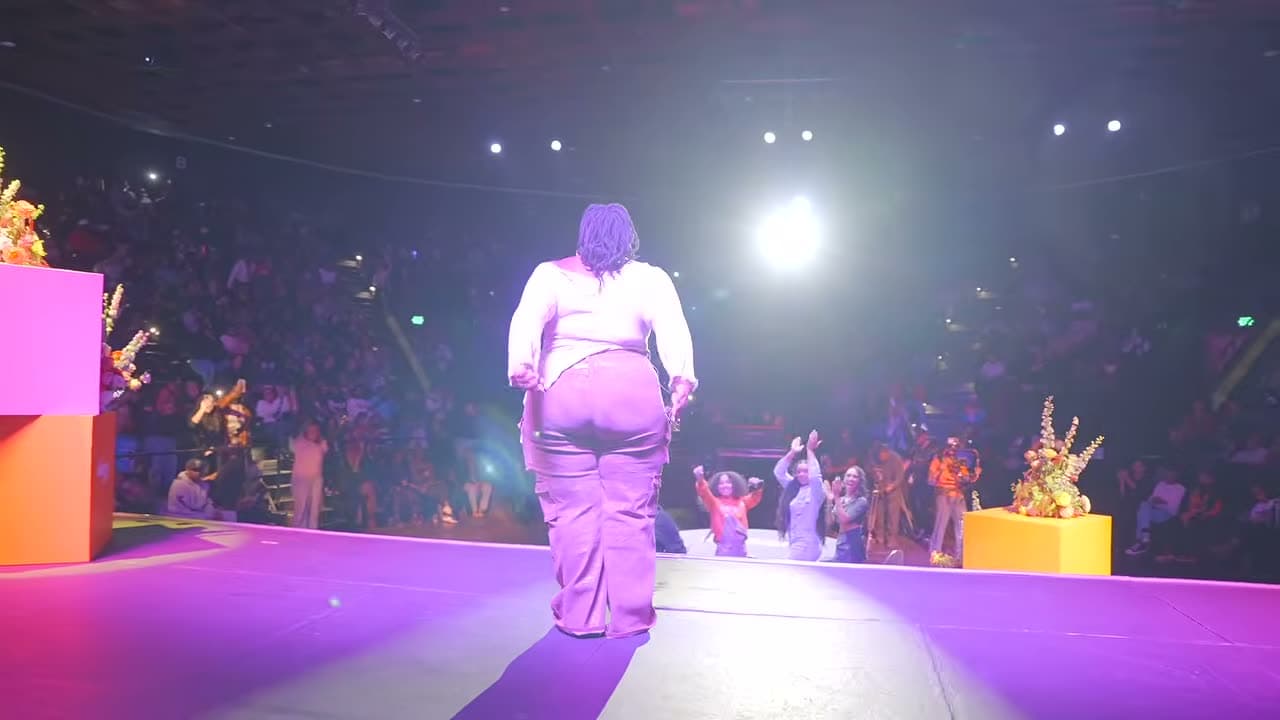 A performer walking out to the crowd, lit from behind