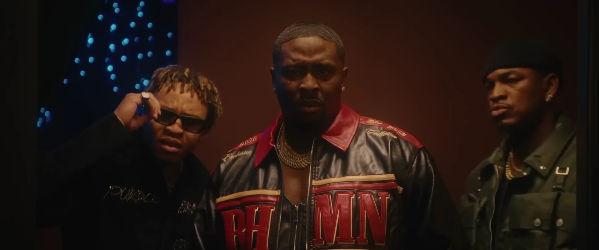 The three artists standing shoulder to shoulder in a lounge, from the Sweet Gurl video