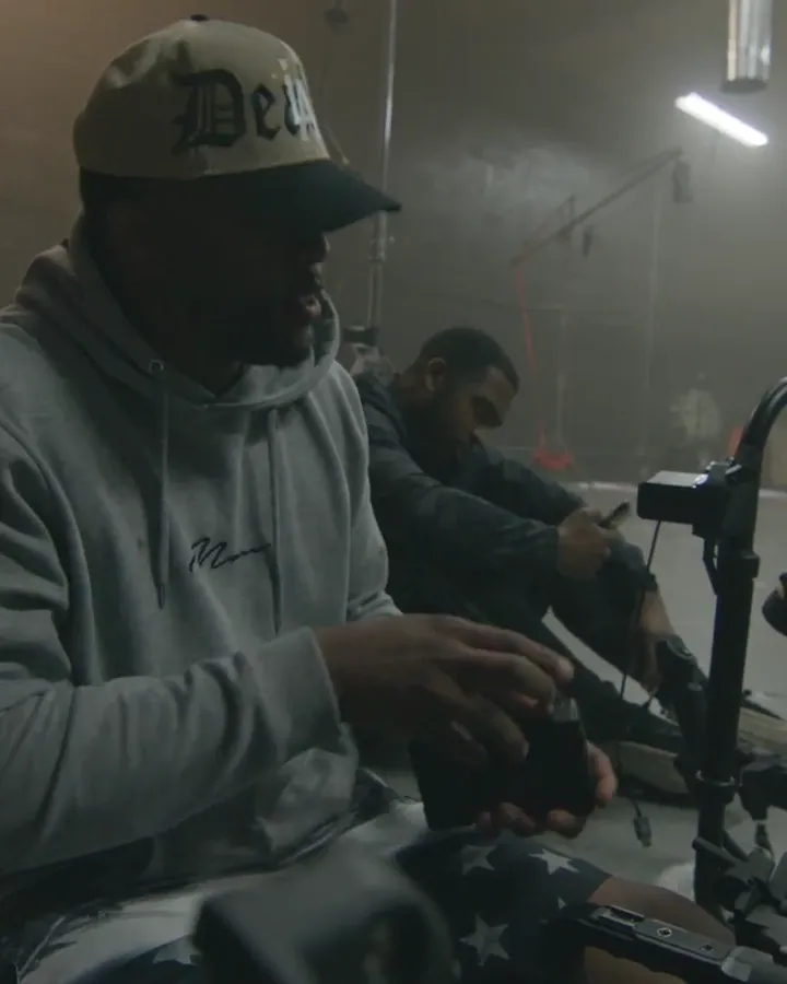 A camera operator building a rig on set